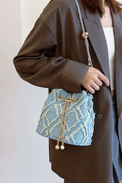 Chain Drawstring Raw Edge Denim Bucket Bag - Premium Crossbody Bag from Trendsi - Just $34.99! Shop now at Handbags Specialist Headquarter